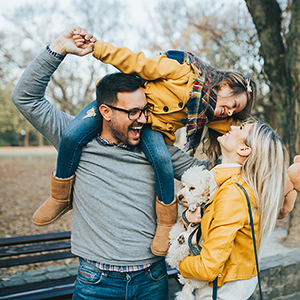 Male with child on shoulders with female holding puppy