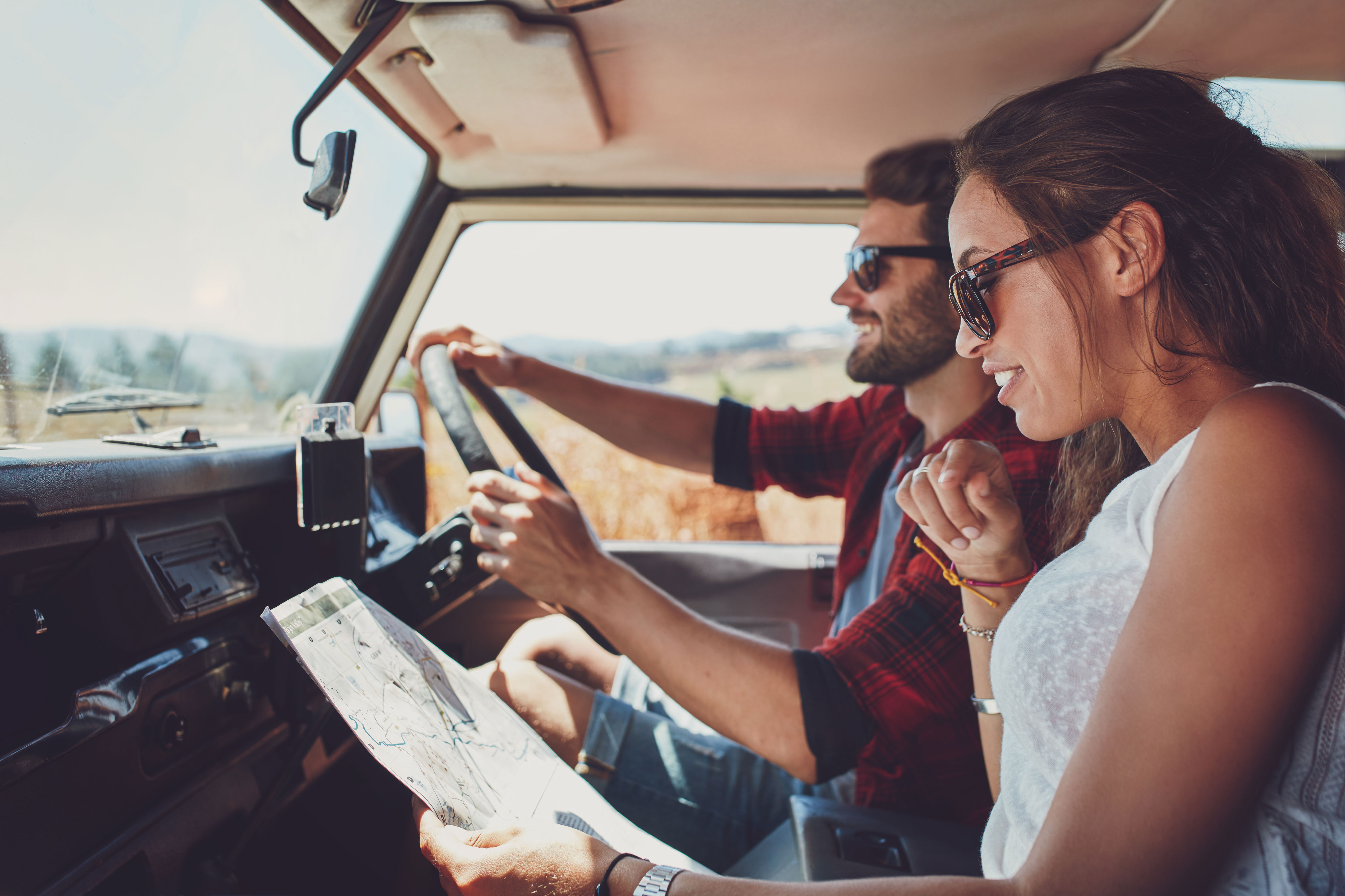 Couple driving in new car looking at map