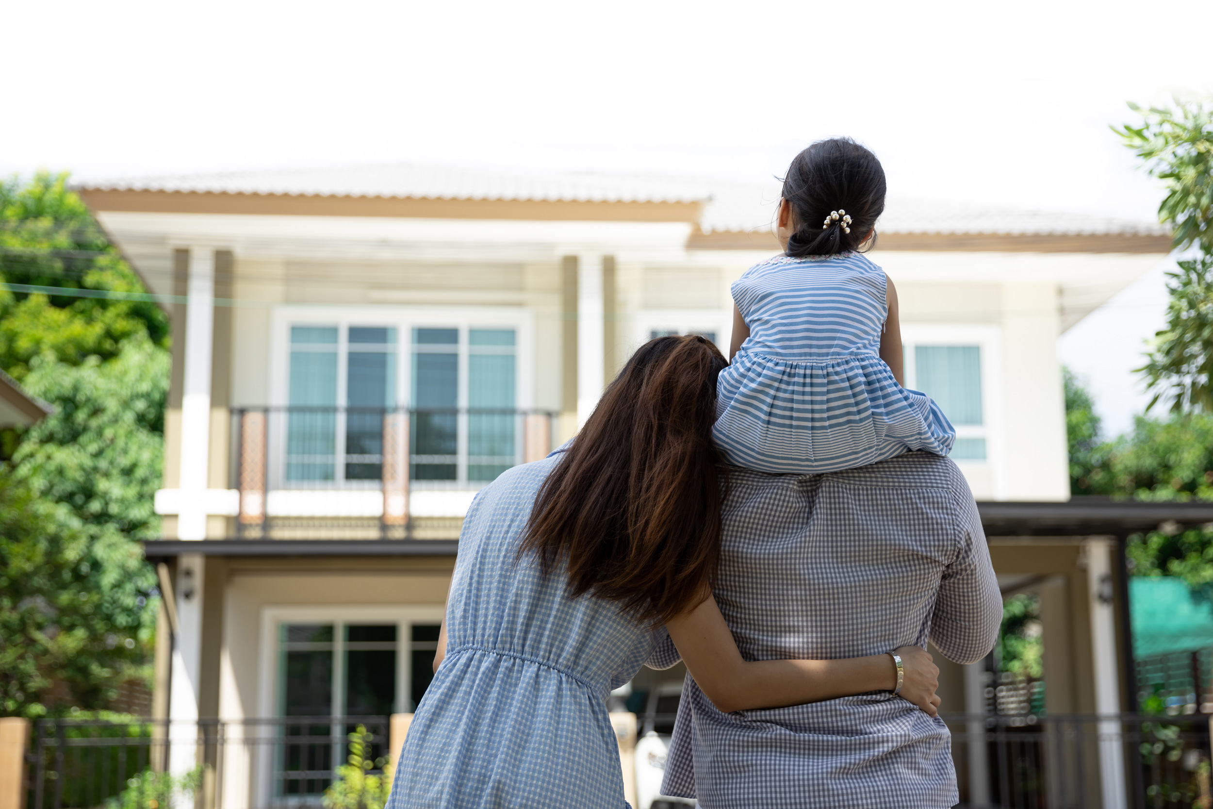 Father mother and daughter looking at new house