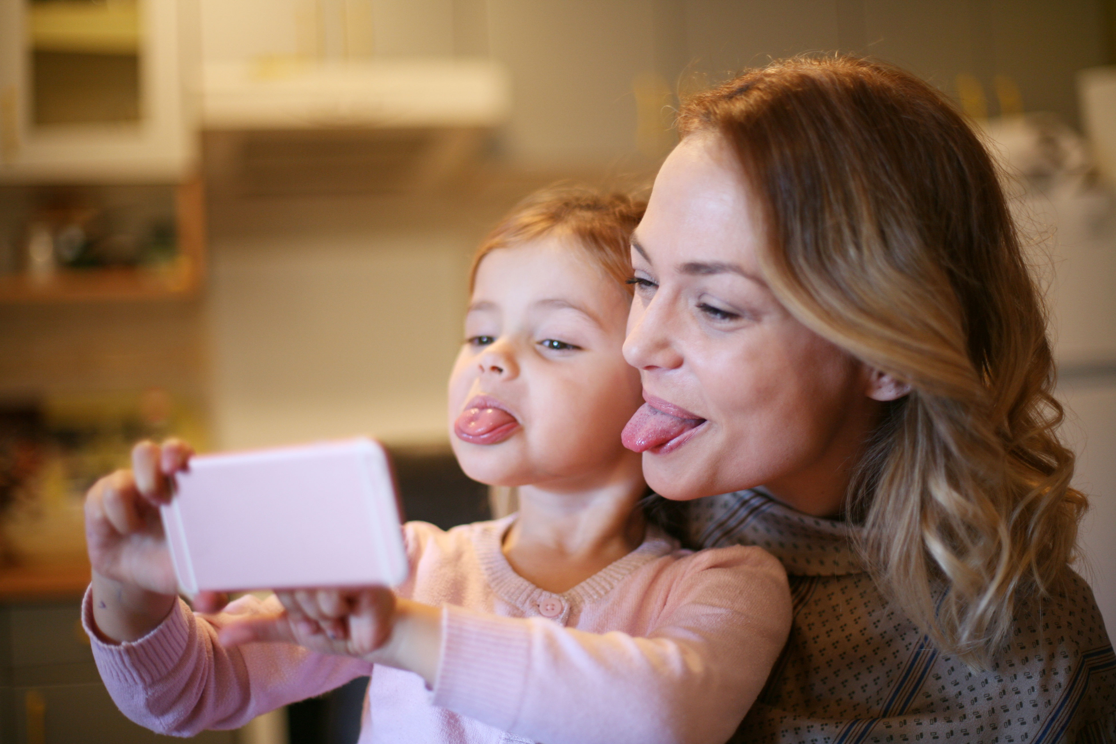 Mother and daughter taking selfies with phone