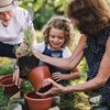 Grandparents teaching grandaughter how to garden