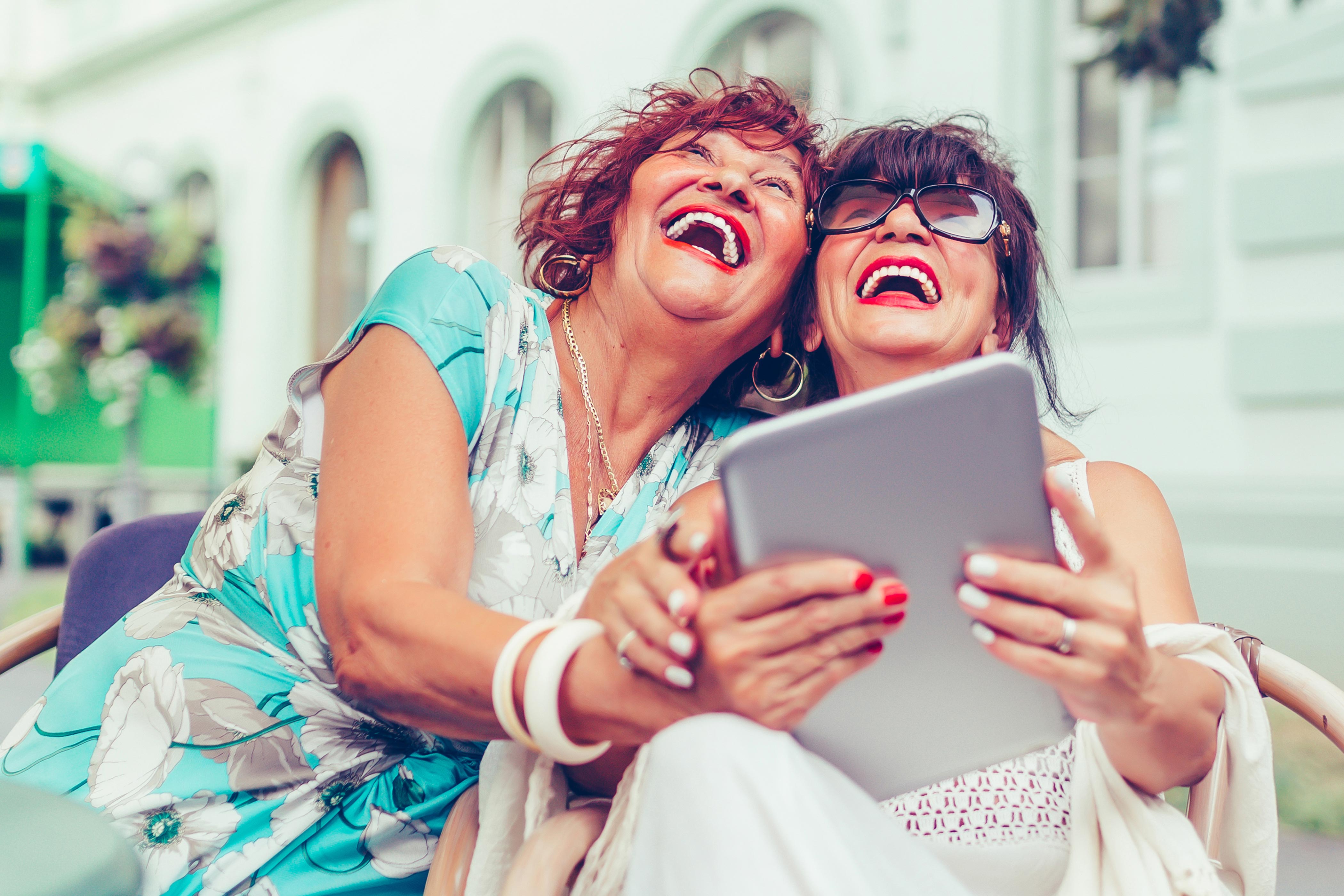 Two older women happy with iPad 